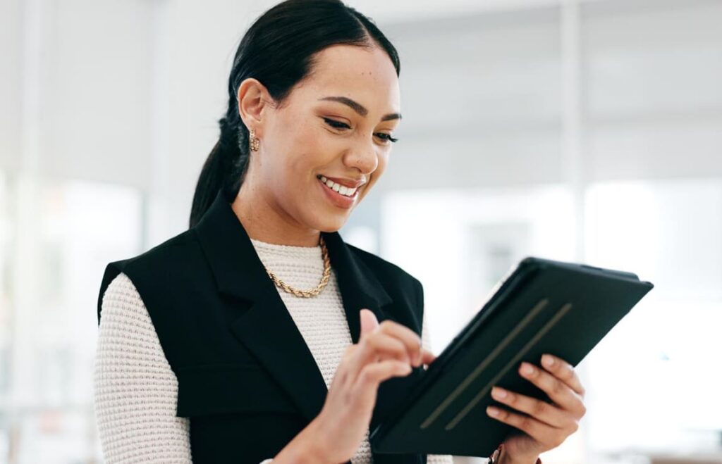 Mulher analisando legislação no tablet para entender como funciona pagar multa de trânsito no Brasil