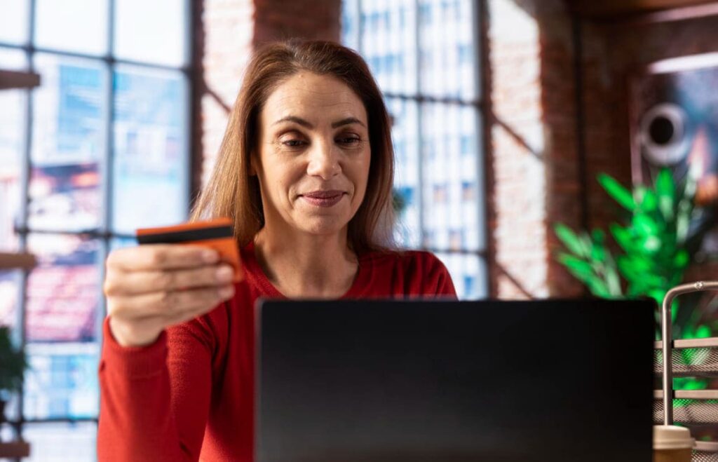 Pessoa conferindo dados no computador para pagar multa de trânsito com segurança e evitar golpes.