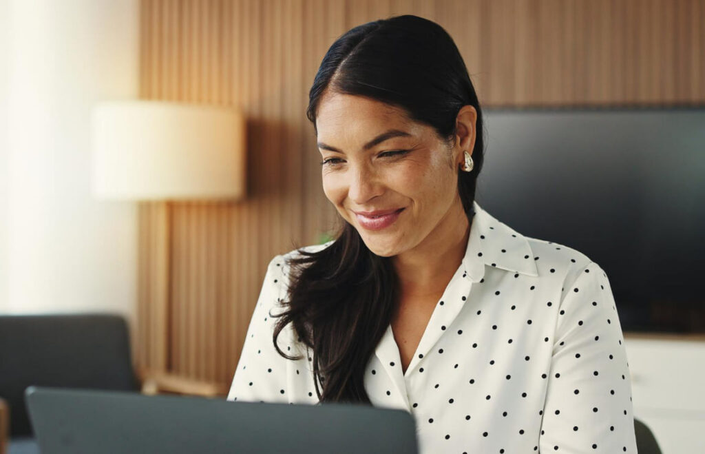 Mulher organizando finanças no computador para antecipar a IPVA 2026 consulta com segurança.